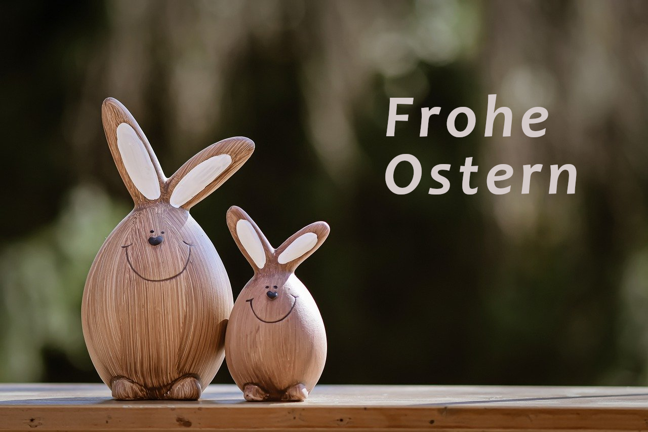 zwei Osterhasen aus Holz mit der Beschriftung "Frohe Ostern"